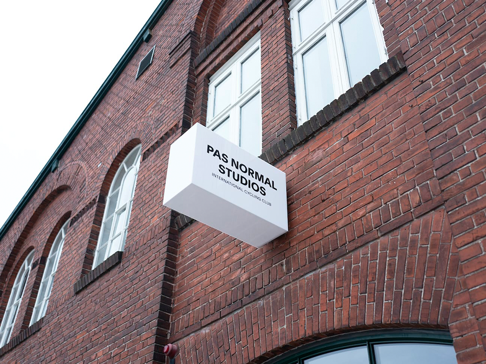 Pas Normal Studios sign on red brick building with arched windows, Copenhagen